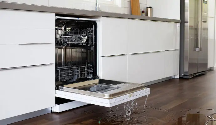Water pooling on a kitchen floor from a dishwasher leak